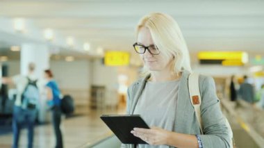 Uluslararası Havaalanı Terminal iş kadını. Hareketli yürüyen merdiven teyp üzerine sürmek, bir tablet kullanır