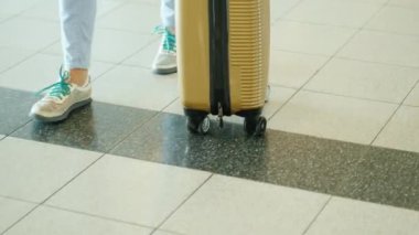 Gezici bir çanta ile kadın bir gezgin Havaalanı terminal yürüyor. Çerçevede sadece bacaklar görülebilir
