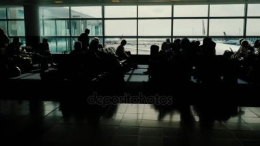 Bir yolculuk beklentisiyle tanınmaz halde insan siluetleri. Büyük Havaalanı Terminal