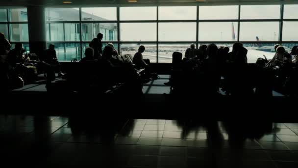 Silhouette di persone irriconoscibili in previsione di un viaggio. Terminal del grande aeroporto — Video Stock