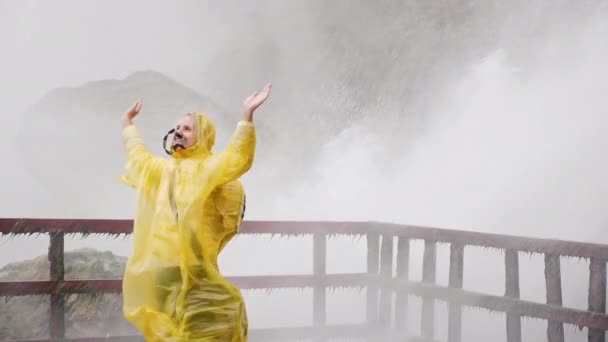 Mulher sob os riachos de água Niagara Falls. Alegra-se e admira o poder da natureza. Vídeo em câmera lenta — Vídeo de Stock