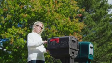Genç bir kadın bir açık havada posta posta alır