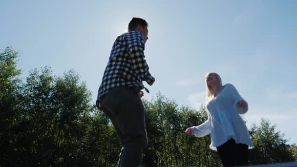 Hoppa högt mot solen. Unga multietniskt par ha kul tillsammans. Slow motion video — Stockvideo