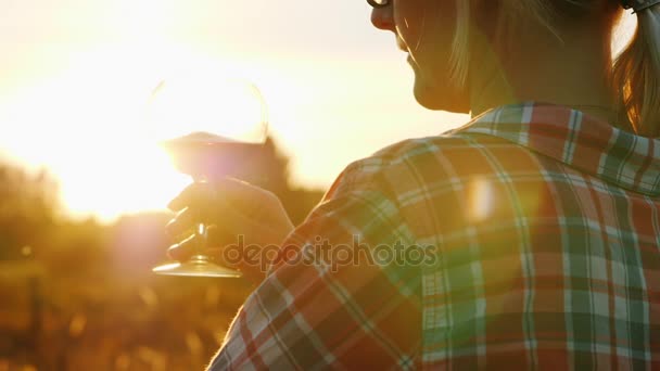 Una mujer irreconocible está probando vino tinto al atardecer. Concepto de turismo y vinificación — Vídeos de Stock