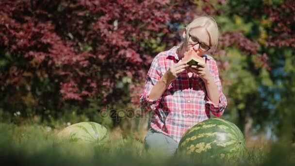 Женщина ест вкусный арбуз. Фермер, хорошая концепция урожая — стоковое видео