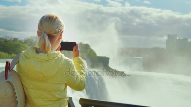 一位女游客在美国拍摄尼亚加拉大瀑布的照片。美国和加拿大的旅游理念 — 图库视频影像