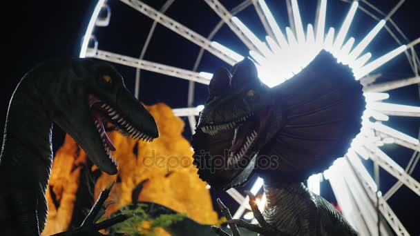 Niagara Falls, Ontario, Kanada, szeptember, 2017: Dinoszauruszok a vidámpark. A háttérben egy izzó óriáskerék — Stock videók