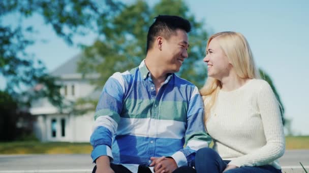 Aziatische man en Kaukasische vrouw praten in de buurt van zijn huis — Stockvideo
