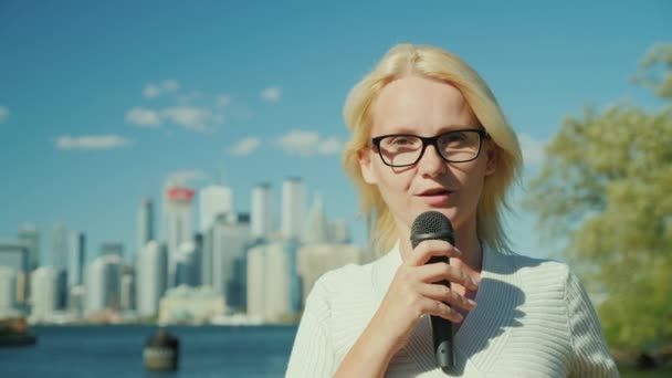 Una giornalista e presentatrice televisiva parla in un microfono sullo sfondo della città. Toronto, Canada — Video Stock