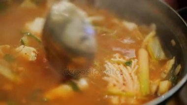 Sıcak çorba deniz ürünleri Kepçe dökün. Otantik Kore mutfağı