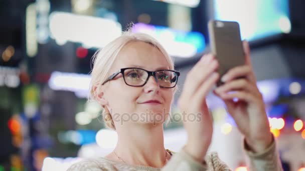 Egy nő egy turista-ban egy nagy város. Csodálattal lefényképezett egy smartphone. A Times Square, New York — Stock videók