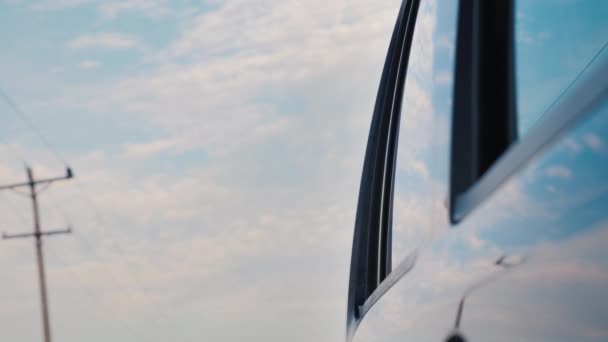 El coche pasea por el campo. Refleja los polos del cielo y de la línea eléctrica — Vídeos de Stock