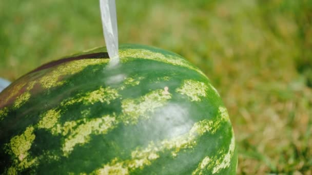 Macht das Messer einen Schnitt an einer großen Wassermelone. Nahaufnahme — Stockvideo