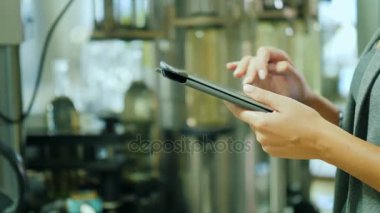 Bir kişi bir tablet şarap üretmek için kullanır. Eller bir konveyör zemin üzerine Close-Up