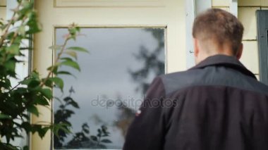 Posta çalışan parsel sunar. Bir kadın bir kutusu alır ve onun giriş işaretleri