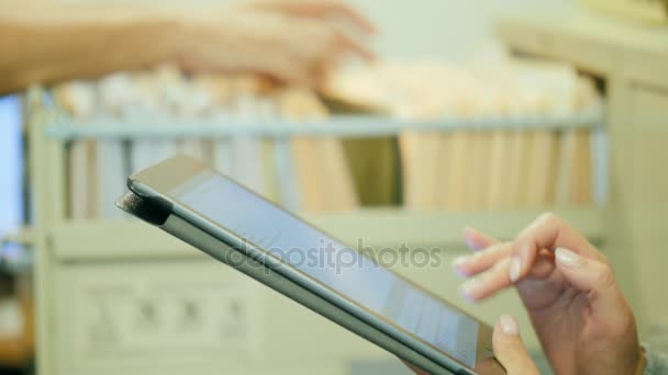 Dos hombres de negocios trabajan con documentos. Un hombre mira a través de documentos de papel en un cajón, una mujer al lado de la tableta. Auditoría o inspección financiera — Vídeos de Stock
