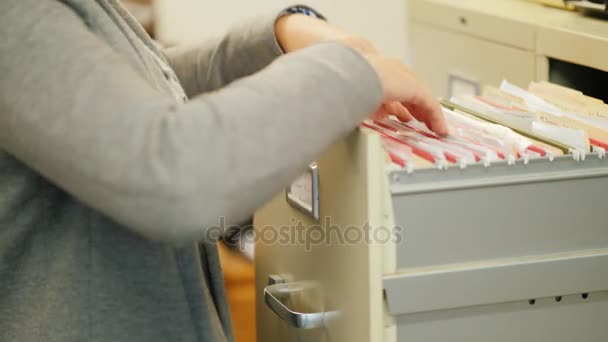 Close-up de mãos femininas tomar uma pasta com documentos de uma gaveta em estilo retro. Trabalho arquivado — Vídeo de Stock