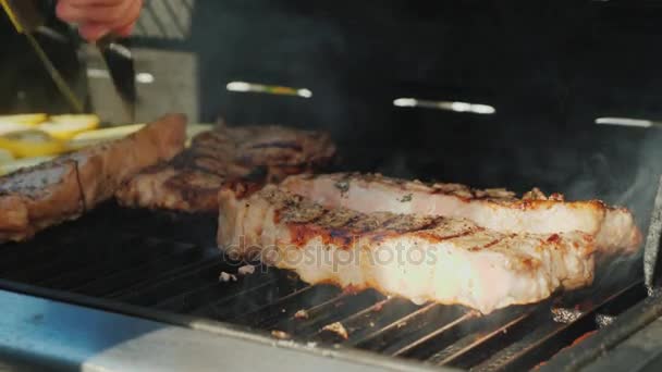 Dale la vuelta a los jugosos trozos de carne. Auténtica barbacoa americana . — Vídeos de Stock