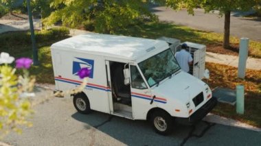 Rockville, Md, Usa, Ekim 2017: Postacı harfler posta kutularını apartment building yakınındaki koyar. Beyaz usps araba Servisi