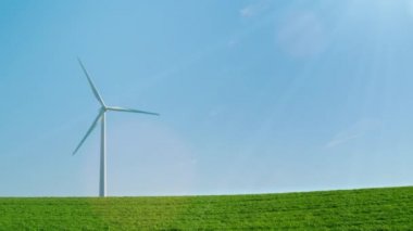 Saf enerji - güneş ışınlarının yeşil bir tepede bir rüzgar jeneratörü pastoral bir resim