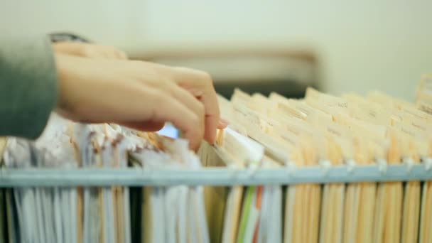 Primo piano: una donna apre un cassetto, guarda gli appunti. Lavorare con documenti archiviati — Video Stock
