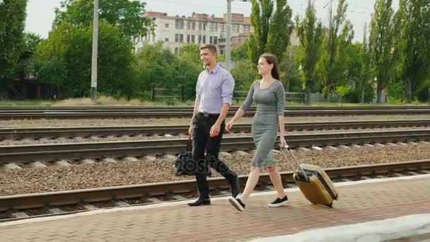 Two businessmen with luggage go along the railroad. Business travel partner — Stock Video