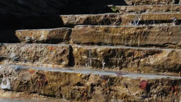 El agua fluye a través de los antiguos escalones de piedra — Vídeo de stock