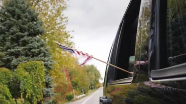 Bir Amerikan bayrağı yardım seyahat araba pencereden görünüyor. Slow Motion video