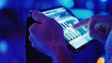 Müzisyen bir tablet bir konserde kullanır. Sesi ayarlar