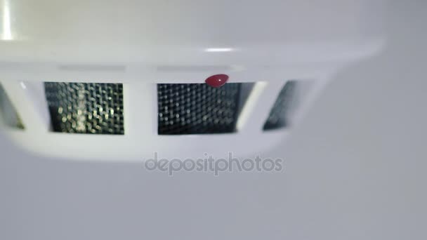 Tiro de close-up: O detector de fumaça é acionado por um toque de dum, o indicador vermelho acende. Fundo branco — Vídeo de Stock