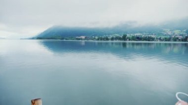 Spor takım elbiseli bir kadın dağ gölü sabah erken hayran. Bir akıllı telefon elinde tutuyor. Steadicam atış