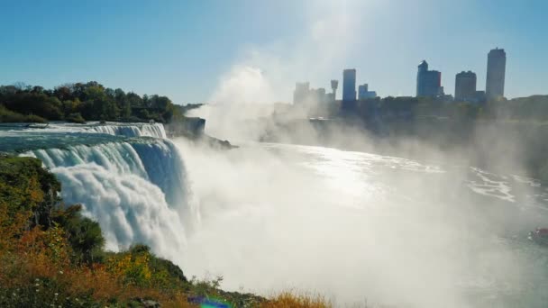 A híres vízesés Niagara-vízesés, a világ minden tájáról érkező turisták körében népszerű helyszínen. Mögött a vízesés látható épület a kanadai oldalon a folyó — Stock videók