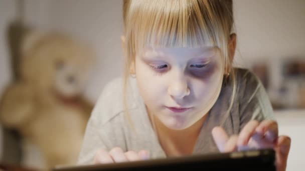 Retrato de uma criança desfrutando de um tablet com um quarto . — Vídeo de Stock