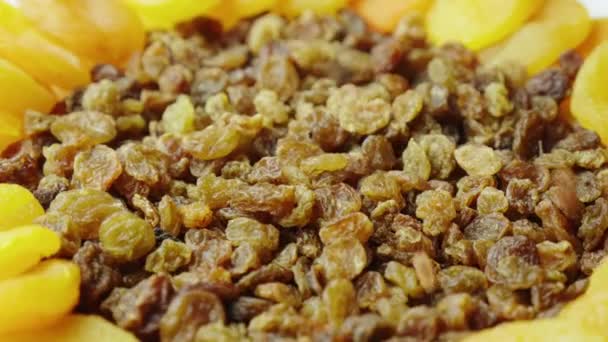 Berries of raisins fall on a plate, drying fruits - raisins and dried apricots. Ingredients of festive dishes for Easter — Stock Video