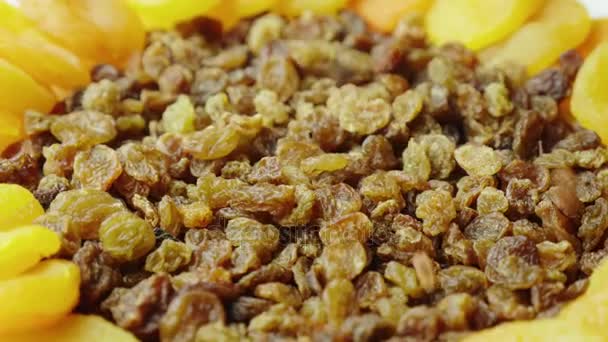 Les baies des raisins secs tombent sur l'assiette, les fruits secs - les raisins secs et les abricots secs. Ingrédients des plats de fête pour Pâques 