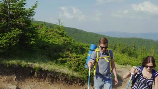 Ein junges Ehepaar erklimmt einen Berg. aktiver und gesunder Lebensstil — Stockvideo