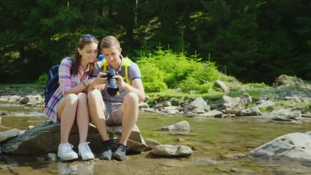 Good memories of the vacation. A couple of tourists are browsing photos on a digital camera — Stock Video