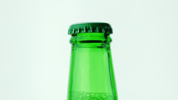 El cuello de una botella de cerveza verde. Cerrado con cubierta metálica — Vídeos de Stock