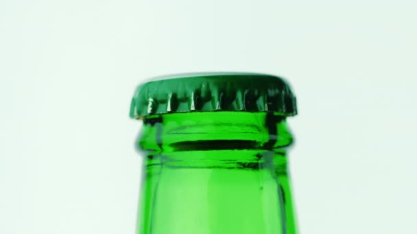 Der Hals einer Glasflasche mit einem Getränk ist mit einem grünen Deckel bedeckt. — Stockvideo