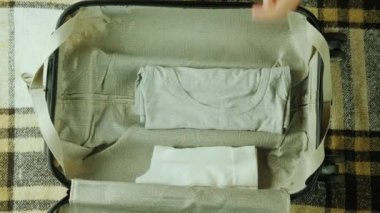 Ateş Hendheld: bir kadın bavul bir paketleme. Bu şeyler koyar birlikte seyahat için.