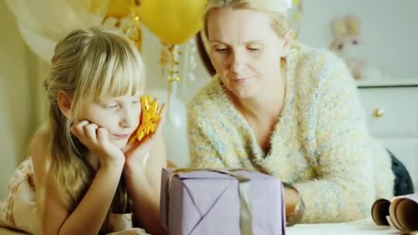 Moeder en dochter zijn samen cadeautjes inpakken. Gelukkig familie, activiteit met een kind — Stockvideo