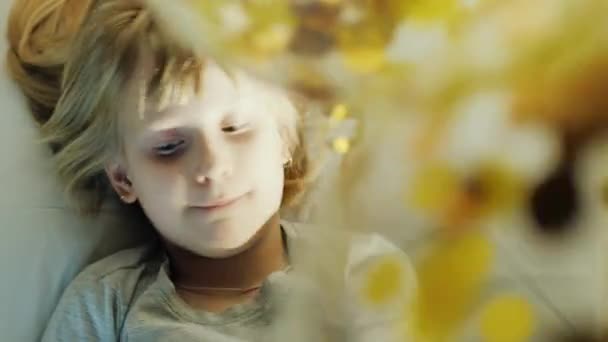 Fille blonde jouant avec des ballons. Allongé sur le lit, frappant ses couilles, riant 