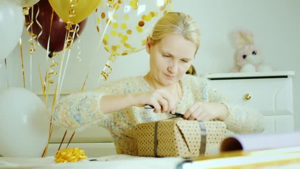 Una mujer está preparando una sorpresa para el cumpleaños del niño. Paquetes regalos en el dormitorio de los niños — Vídeos de Stock