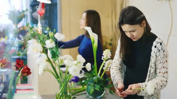 Флористы делают цветочные букеты, работают в цветочном магазине. Концепция доставки и заказа цветов — стоковое видео