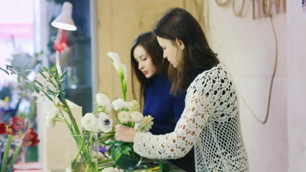 Две женщины работают в цветочном магазине. Делай букеты. Торговля и поставка свежих цветов — стоковое видео