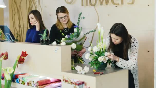 꽃집의 집단 꽃이 게에서 작동합니다. 판매를 위해 꽃다발을 준비. — 비디오