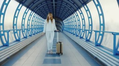 Terminal havaalanı ya da tren istasyonunda geçiş genç iş kadını ile seyahat çantası gezici açıktır