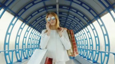 Şık bir kadın alışveriş torbaları ile gelir. Evet. Başarılı alışveriş kavramı