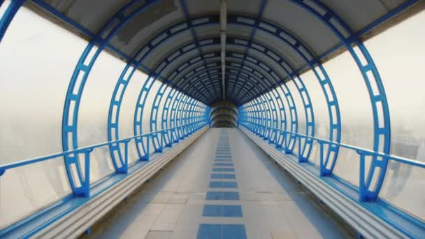 Una telecamera che vola attraverso un tunnel di vetro. Il passaggio tra i terminal dell'aeroporto o della stazione ferroviaria. Video POV — Video Stock