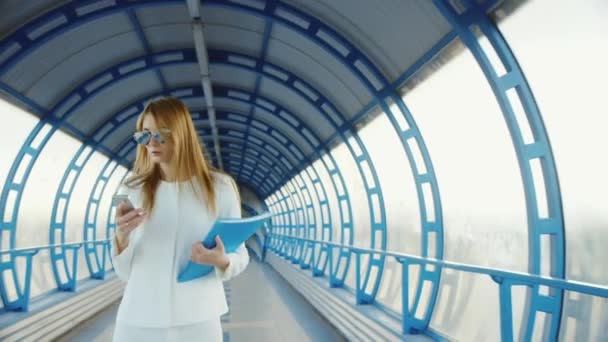 Business woman in a suit talking on modern transition, holding a folder with documents and phone — Stock Video